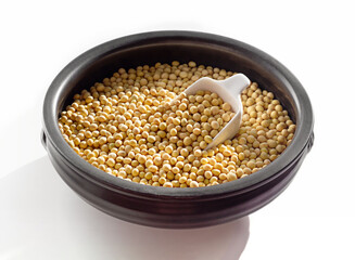 Soybeans in black pottery. Isolated on white background. 
