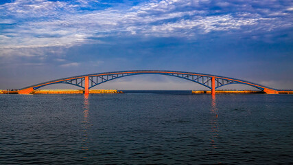 Amazing cirrus cloud view and beautiful arch iron bridge in the early morning form a scenic sea scene.High quality photo  in Magong City, Penghu County, Use in branding, screensavers, websites, etc.