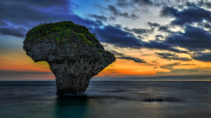 A vase-shaped rock stands on the silky sea before sunrise.charming sky cloudy cloudscape,silky sea...