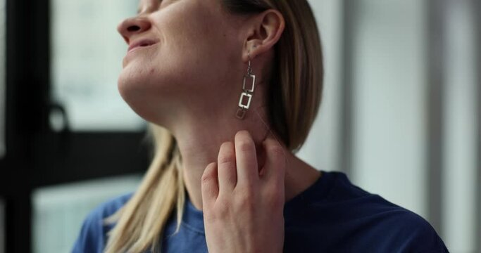 Woman scratches neck skin because of eczema irritation