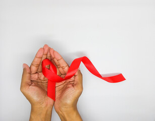 AIDS red ribbon on woman's hand prevention support for World aids day and national HIV AIDS...