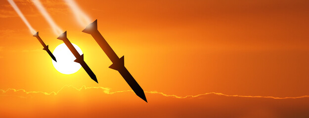 Fired missiles fly to the target. Missiles at the sky at sunset. Missile defense. Rockets attack concept. - obrazy, fototapety, plakaty