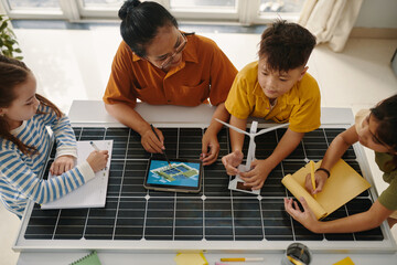 Gen alpha kids discussing renewable energy sources with teacher in class