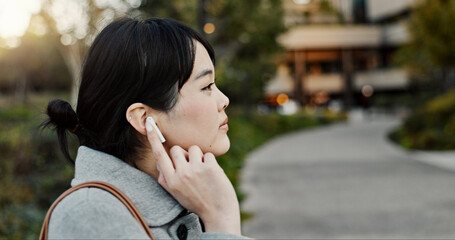 Japanese woman, earphones and walk in city with listening, music and streaming subscription on...