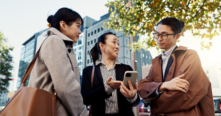 Phone, business and group of people in city on internet, social media or reading email together in Japan. Smartphone, happy and friends in urban town on technology, networking and mobile app in Tokyo