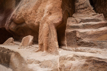 Partially preserved sculpture of a camel driver and a camel carved into sand rock of Al Siq gorge in Nabatean Kingdom of Petra in Wadi Musa city in Jordan