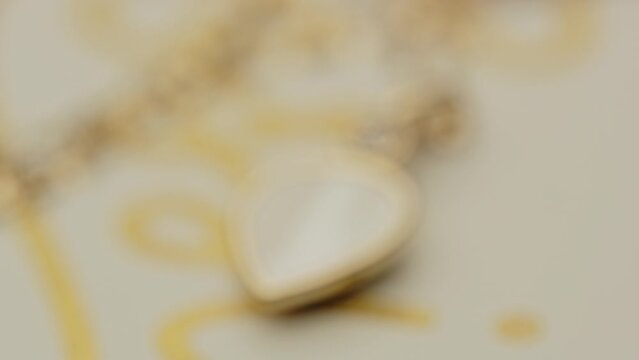 Extreme close up of a beautiful golden locket on a necklace slowly going into focus