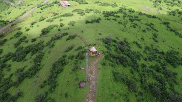 Drone shot of Hindu temple at the edge of the mountain surrounded by lush greenery, Trimbakeshwar, Nashik, India