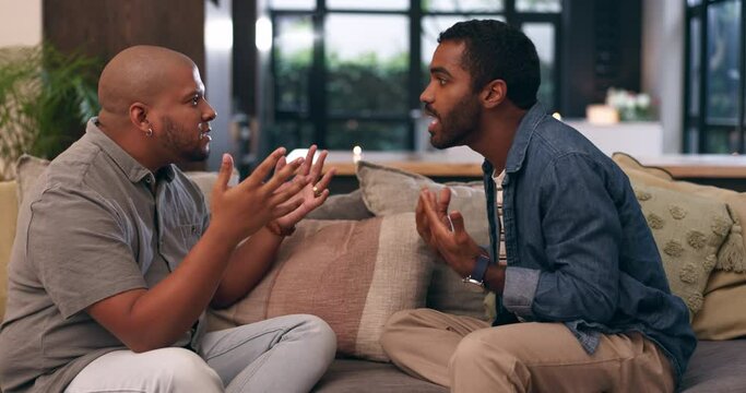 Couple, gay and fighting on conflict in living room, communication and angry or queer relationship at home. LGBT, couch and stress or argument for divorce, jealous and frustration for toxic marriage