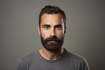 Portrait of a handsome man with a beard on a gray background