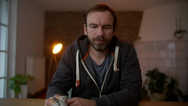 Adult male enjoys hot drink and contemplates the next task to undertake