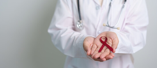 Doctor with Burgundy Red Ribbon for March multiple myeloma Cancer and December World Aids Day...
