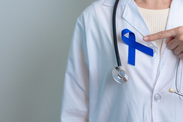 March Colorectal Cancer Awareness month, doctor with dark Blue Ribbon for supporting people living...