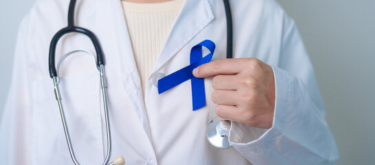 March Colorectal Cancer Awareness month, doctor with dark Blue Ribbon for supporting people living...