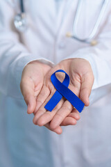 March Colorectal Cancer Awareness month, doctor with dark Blue Ribbon for supporting people living...