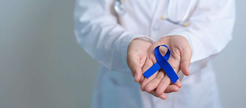 March Colorectal Cancer Awareness month, doctor with dark Blue Ribbon for supporting people living and illness. Healthcare, hope and World cancer day concept - Powered by Adobe