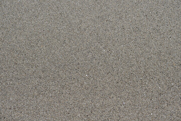 Sea sand top view flat lay. Gray sea sand on the seashore. Sea sand closeup flat lay.