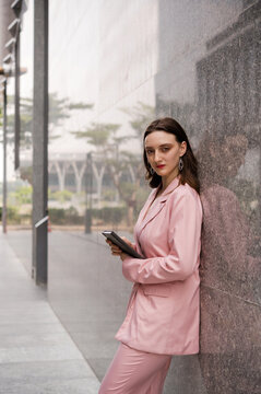 Young confident business woman in pink suit outdoor 