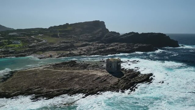 Waves whitewash breaking at La Pelosa Tower, Sardinia. Aerial