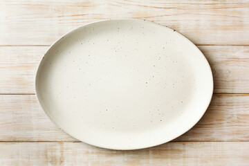 An empty oval dish on a wooden background. Top view. Copy space.