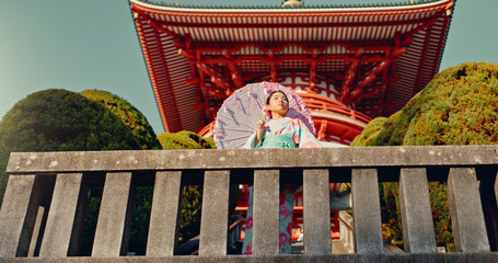 Japanese woman, umbrella and shinto temple with traditional clothes, culture and religion in...
