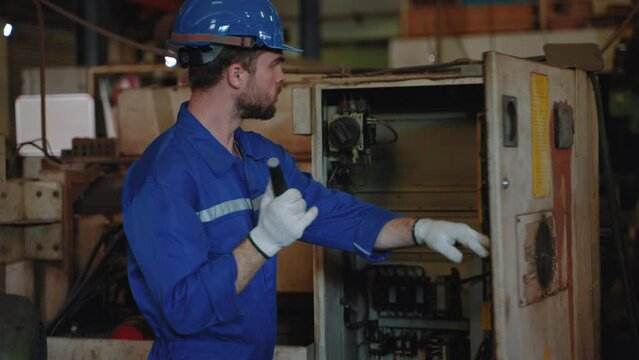 Technician inspecting main switch board in factory
