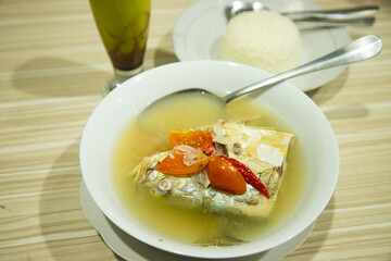 Fresh and delicious cooked fish in yellow sauce served in a white bowl