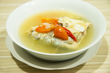 Fresh and delicious cooked fish in yellow sauce served in a white bowl