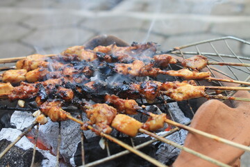 The process of grilling chicken satay on a traditional stove