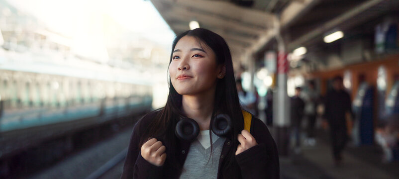 Asian, woman at train station for travel, commute or holiday with smile on face and freedom outdoor. Railway, walking on platform and transportation, journey for adventure in China with happiness