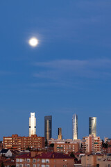 Fototapeta na wymiar The moon over the four towers in the city of Madrid, Spain