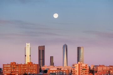 The moon over the four towers in the city of Madrid, Spain