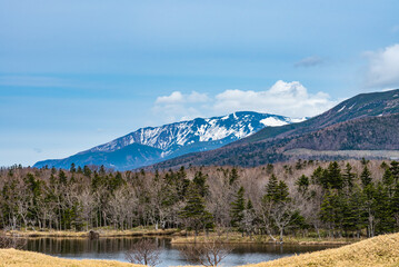 Beautiful lake and rolling mountain range on springtime sunny day. High latitude country natural beauty scenery. The First Lake of Shiretoko Goko Five Lakes, Shiretoko National Park. Hokkaido, Japan