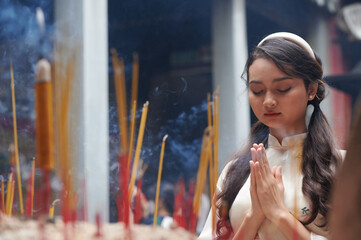 Young Vietnamese girl praying in the pagoda for good things ahead