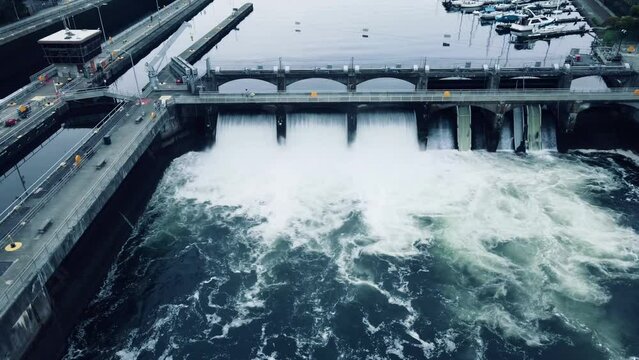 Stationary aerial view of water cascading down the Ballard Locks on an overcast day in Seattle, WA.