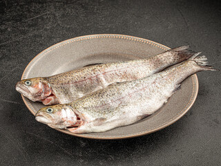 Two fresh raw seabass fishes on a plate