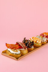 bruschetta on a fresh baguette on a pink background