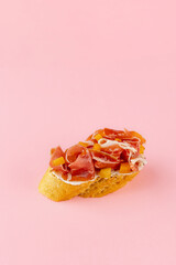 bruschetta on a fresh baguette on a pink background