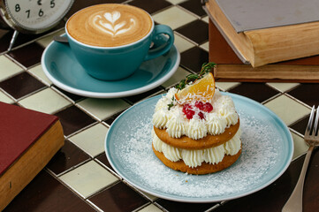 coffee and dessert are on the table, watches and books are nearb