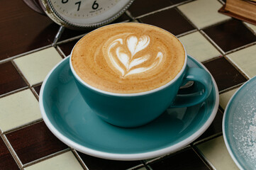 coffee in a cup on the table . watches and books are lying next