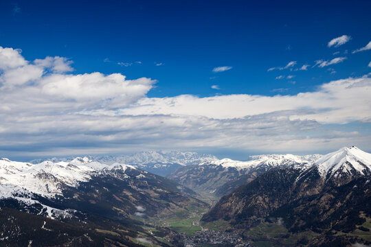 Top view of narrow valley with villages in Austrian Alps. Bright sky