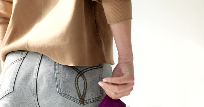 Back view of woman pulling condom out of her pants pocket 4k movie slow motion. Contraception as prevention of sexually transmitted infections concept