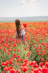 Woman poppies field. Back view of a happy woman with long hair in a poppy field and enjoying the beauty of nature in a warm summer day.