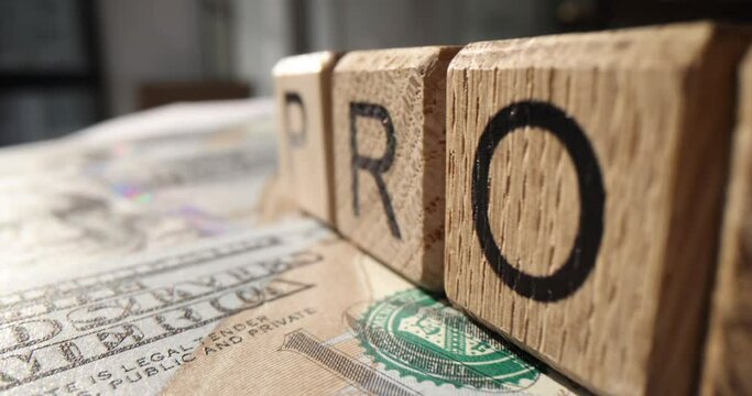 Profit on wooden cubes on money dollar bills closeup 4k movie slow motion. Successful business concept