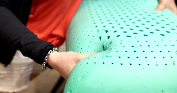 Orthopedic green pillow and memory foam in female hands. Pillow filler