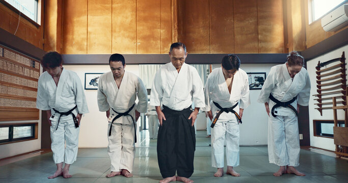 Martial arts group, men and bow at training, respect or honor for fight, conflict or competition in dojo. Senior sensei, Japanese students and together for aikido with exercise, workout or discipline - Powered by Adobe