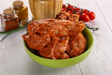Raw turkey shoulder wing in Indian tandoori marinade