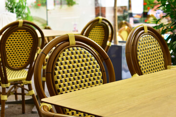 Wicker yellow-brown chairs in an outdoor cafe. Vintage rural style. Torun, Poland, August 2023