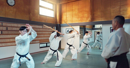 Martial arts people, aikido class and sensei teaching protection, self defense or combat technique. Black belt students, education and Japanese group learning, skill development and practice in dojo