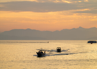 Naklejka premium fishing boat silhouette at sunset